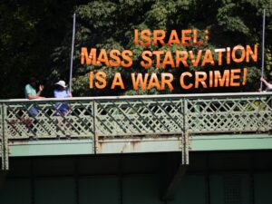 People holding a banner that says "Israel: Starvation is a War Crime